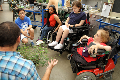 June2015-07a.jpg Four students sit around an instructor with a large plant in the UW greenhouse.
