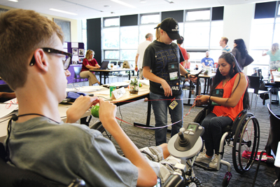 Three students work together on a class project involving ribbons.