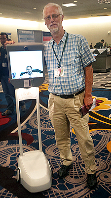 Richard Ladner standing next to Kavita on the monitor of her Beam robot.
