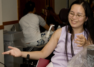Student in a wheelchair smiling. Photo of student in a wheelchair smiling.