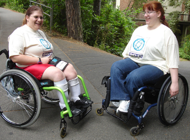 Photo of two students in wheelchairs outside on the UW campus.