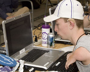 Picture of student with mobility and hearing impairments working on his laptop.