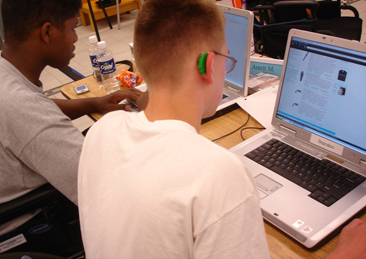 Photo of two students working on laptop computers.