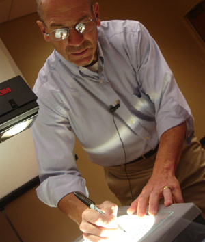 Photo of professor drawing on an overhead projector.