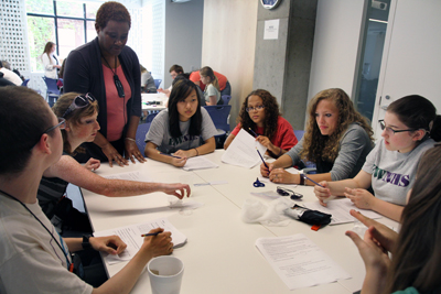 A group of students sits around a table to work on a project together during Summer Study 2012. Photo of students around a table working on a project together during Summer Study 2012.