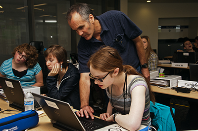 A mentor assists a participant with a computing project.