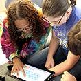 Two deaf students use a tablet.