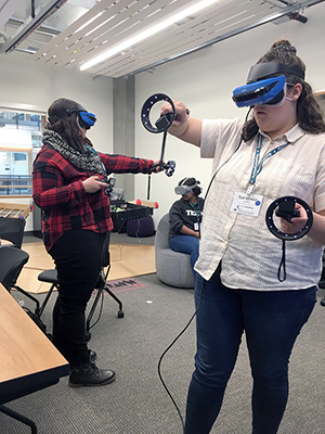 Two people using virtual reality headsets in a classroom