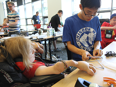 Students working on making tetrahedron kites Image of two students working on making tetrahedron kites