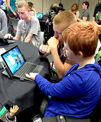 DO-IT Intern Kayla and Phase I Scholar London look at a computer with new Windows 10.