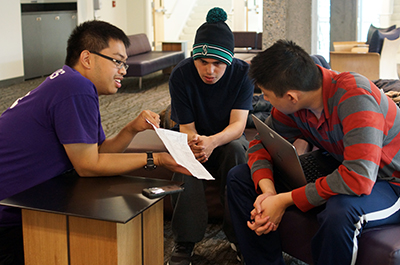 DO-IT Interns Dustine and Antonio help Phase II Scholar Alex with a project.