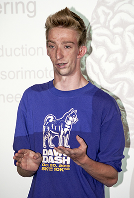 A DO-IT Ambassador talks in front of a crowd during a neurobiology presentation.