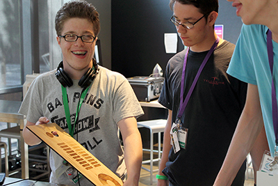 A student laughs with other students in the makerspace.