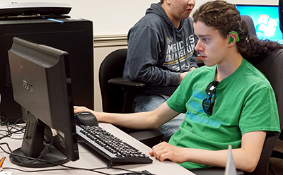 A student with a cochlear uses a computer.