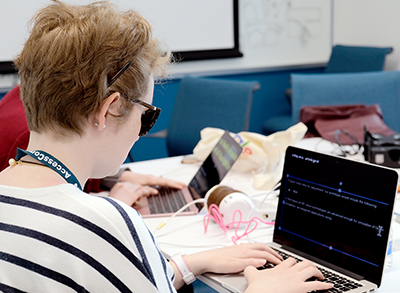 A student with a visual disability codes on a computer during last year's OurCS workshop.