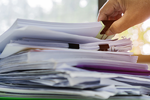 A hand picks up a stack of papers A hand picks up a stack of papers
