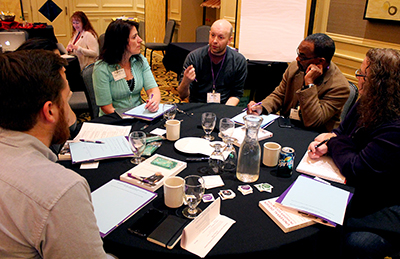 One person speaks to a table of people.