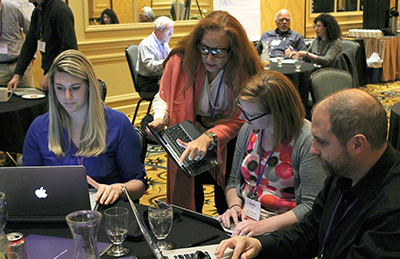 One participant shows another something on her computer.