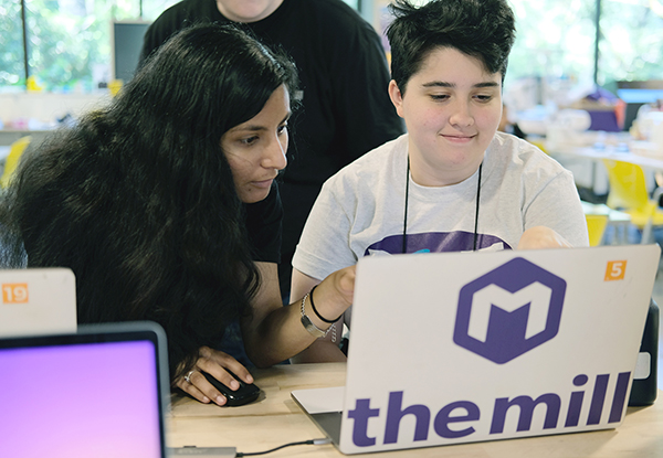 An educator from the UW Makerspace helps a student with a disability on a computing project.