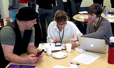 Three participants look at resources online together.