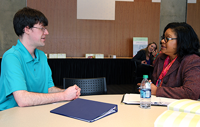 A student practices interview skills with a professional. A student practices interview skills with a professional.