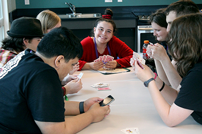 Student smiling while playing a card game.