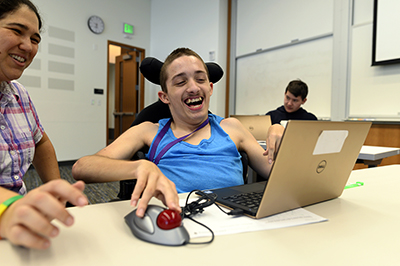 Student uses accessible mouse to use computer. Student uses accessible mouse to use computer.