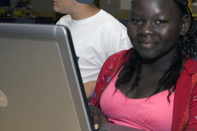 Photo of female student working at a laptop in a computer lab