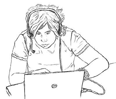 A student uses a headset to speak on his computer. A student uses a headset to speak on his computer.