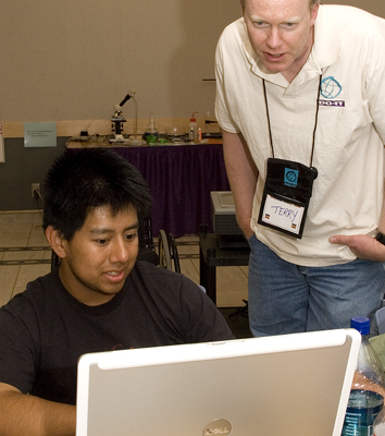 Photo of student and instructor working on laptop.