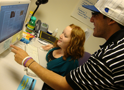 Photo of two students collaborating on a computer.