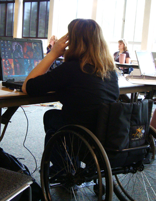 Student in wheelchair uses a laptop. Photo of a student in wheelchair using a laptop.