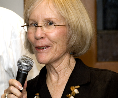 Image of a faculty member holding a microphone giving a presentation