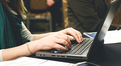 Someone typing on a laptop.