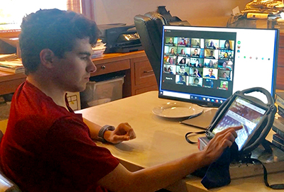 A student uses an alternative communication device while in an online class. A student uses an alternative communication device while in an online class.