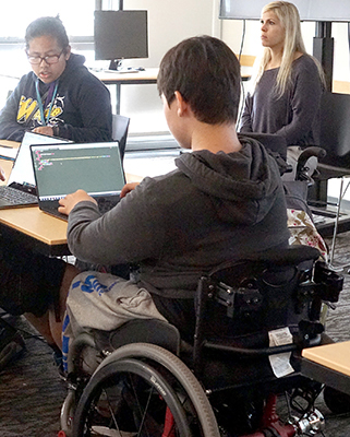A student in a wheelchair using a laptop. A student in a wheelchair using a laptop.