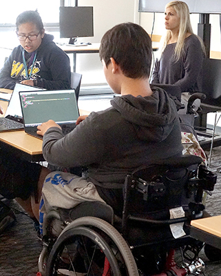 A student in a wheelchair using a laptop.