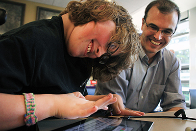 A mentor helps a student on her iPad.