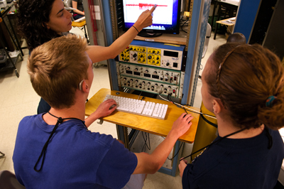 Photo of An instructor shows DO-IT Scholars Lucas and Allison how to use NOAA's equipment.