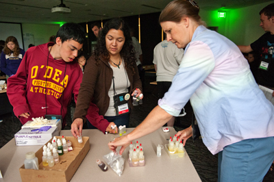 DO-IT Staff member works with scholars to do a science experiment. Photo of DO-IT Staff member works with scholars to do a science experiment.