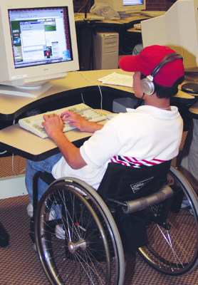 Photo of student in a wheelchair working at a computer workstation