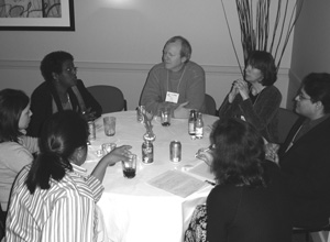 Photo of CBI participants talking at a round table while enjoying something to drink