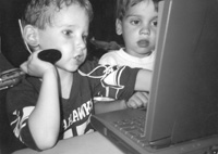 Photo of young children working on a laptop in the computer lab