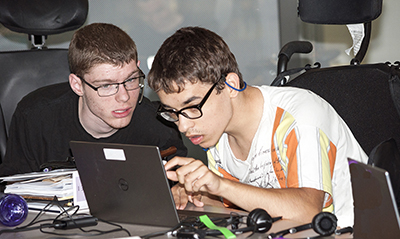 Two students with disabilities use a computer in a classroom.
