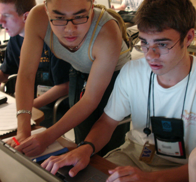 Photo of a student helping another student on a computer