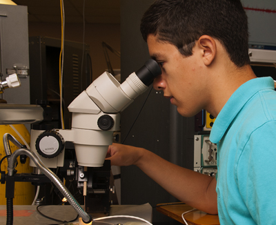 Photo of DO-IT Scholar looking through a microscope.