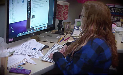 A graduate student works at their desk.