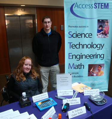 Picture of two DO-IT staff members at an AccessSTEM display showing different equipment for making a science lab accessible