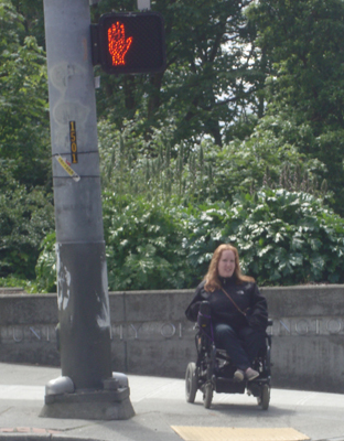 Photo of DO-IT Ambassador Kayla waits to crosswalk near the UW campus