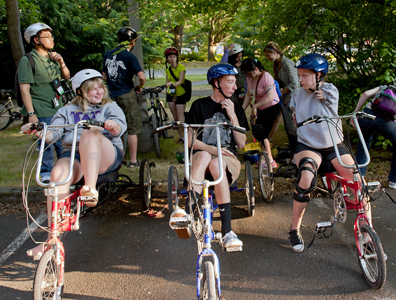 Three Scholars sit on accessible bikes during Outdoors for All.